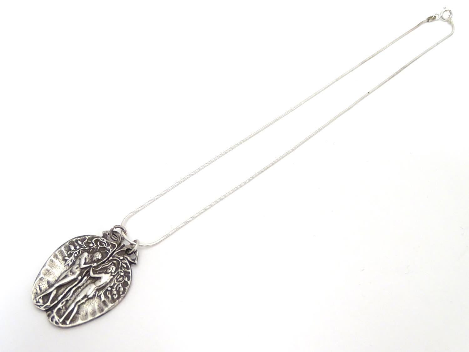 A silver pendant on chain, the pendant formed as an apple with a depiction of Adam and Eve. - Image 3 of 5