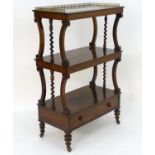 An early 19thC rosewood whatnot with a brass gallery above three tiers with carved and turned