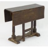 An early / mid 17thC oak gateleg table with a rectangular top above turned tapering supports and a