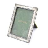 A silver photo frame with crossed ribbon detailing. Hallmarked Birmingham 1913 maker Henry Matthews.