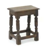 A late 17thC oak peg jointed stool with a rectangular moulded top and raised on turned legs with a