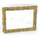 A late 20thC mirror with a pierced giltwood frame and bevelled mirror edge. 36" wide x 27 1/2" high.