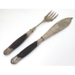 A pair of silver plate fish served wih ebonised handles. 12" long overall Please Note - we do not