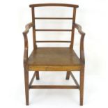 An oak Regency opem armchair of large proportions, having a curved top rail and back rails with