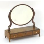 An early 19thC mahogany dressing table mirror, with an oval frame above three short drawers and