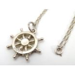 A hallmarked silver pendant on sterling silver chain, the pendant formed as a ship's wheel.