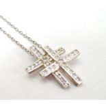 A silver and white metal pendant on chain, the pendant formed as a white stone set double cross.