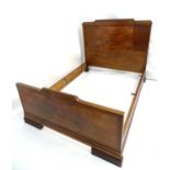 An Art Deco oak and walnut double bed with ebonised stringing and gadrooned feet. 82" long x 60"