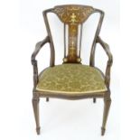 An early 20thC mahogany open armchair with marquetry decoration, decorative stringing, and a