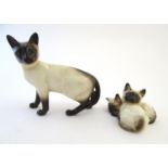 A Beswick model of a standing Siamese cat, model no. 1897. Together with Siamese kittens curled