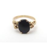 A 9ct gold ring set with black onyx cabochon. Ring size approx H. Please Note - we do not make