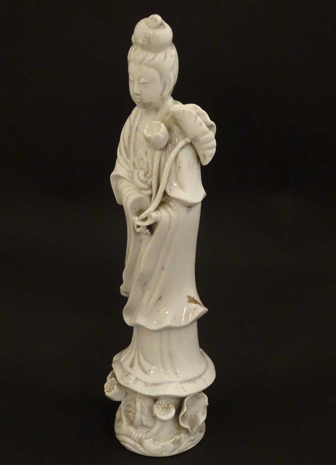 A Chinese blanc de chine figure of Guanyin holding flowers, raised on a base of lotus flowers and - Image 4 of 9