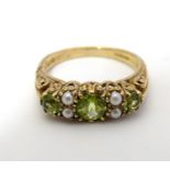 A 9ct gold ring set with peridot and seed pearls Ring size approx O Please Note - we do not make