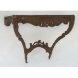 An 18thC carved console table with a carved and shaped apron above carved legs and supporting