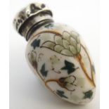 A 19th / 20thC porcelain scent bottle with a silver top, the body having scrolling foliate and