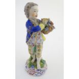 A Dresden porcelain figure of a boy with a basket of flowers. Marked under. Approx. 5 1/4" high