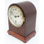 A stained mahogany arch-cased mantel clock having a 4 1/2" silvered dial signed 'Camerer, Cuss &