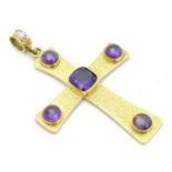 A large 18ct gold pendant of cross / crucifix form set with central facet cut purple stone and