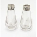A pair of Victorian glass pepperettes with silver tops hallmarked London 1885 maker Jonathan