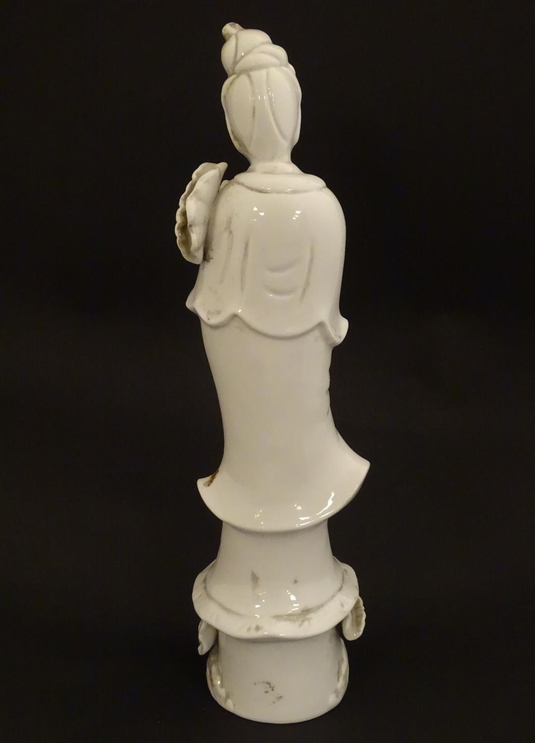 A Chinese blanc de chine figure of Guanyin holding flowers, raised on a base of lotus flowers and - Image 5 of 9