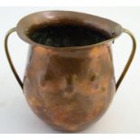 An Arts and Crafts twin handled copper pot with a flared rim and hammered detail. Approx. 6" high