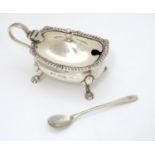 A Silver mustard pot with blue glass liner and associated silver spoon, the mustard pot with