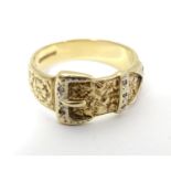 A 9ct gold ring of belt and buckle form with floral detail and chip set diamonds. Please Note - we