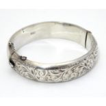 A silver bracelet of bangle form with engraved acanthus scroll decoration. Hallmrked Chester 1952