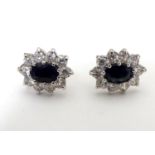 A pair of 9ct gold stud earrings set with blue and white stones in a cluster setting. The setting