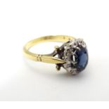 Am 18ct gold ring set with central blue stone bordered by white stones. Ring size approx size N