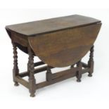 An 18thC oak gateleg table, the drop flaps opening to form an oval table top, the table raised on