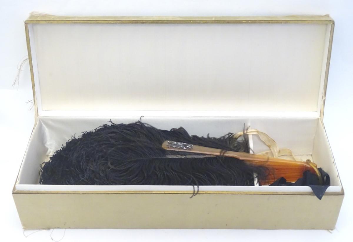 An early 20thC ostrich feather fan, with 18 sticks, the front stick with white metal detail set with - Image 2 of 5