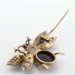A late 19thC / early 20thC brooch formed as a winged insect , with garnet cabochon and opal body and