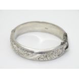 A silver bangle formed bracelet with engraved acanthus scroll decoration. Hallmarked Birmingham 1959