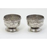 A pair of silver pedestal salts with embossed decoration. Hallmarked Sheffield 1902 maker Martin,