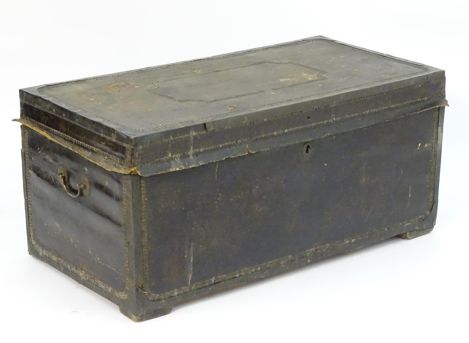 A Regency leather bound camphor wood trunk with brass stud detailing and flanked by carrying