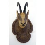 A 20thC carved wooden figure of a chamois deer head on a scrolling quatrefoil mount. Approx. 4 1/