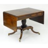 A Regency mahogany sofa table with two flaps, two short drawers and two sham drawers above a