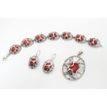 A suite of silver jewellery set with openwork detail and red hardstone cabochon. Comprising
