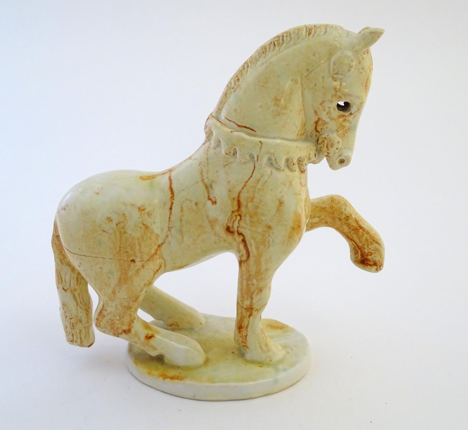 A Paula Humphries studio pottery model of a horse on an oval base. Marked under with impressed bee