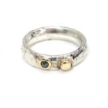 A Contemporary silver ring set with yellow metal and diamond detail. Maker DT . Ring size approx M