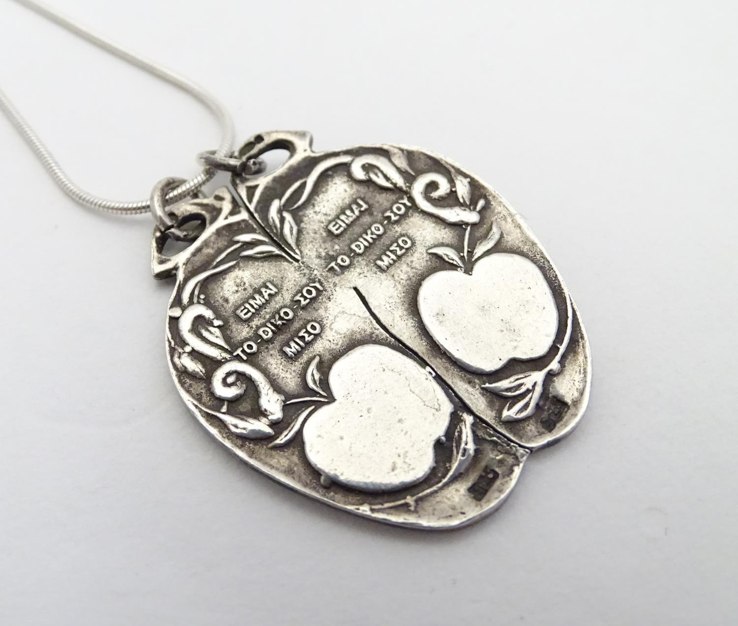 A silver pendant on chain, the pendant formed as an apple with a depiction of Adam and Eve. - Image 4 of 5