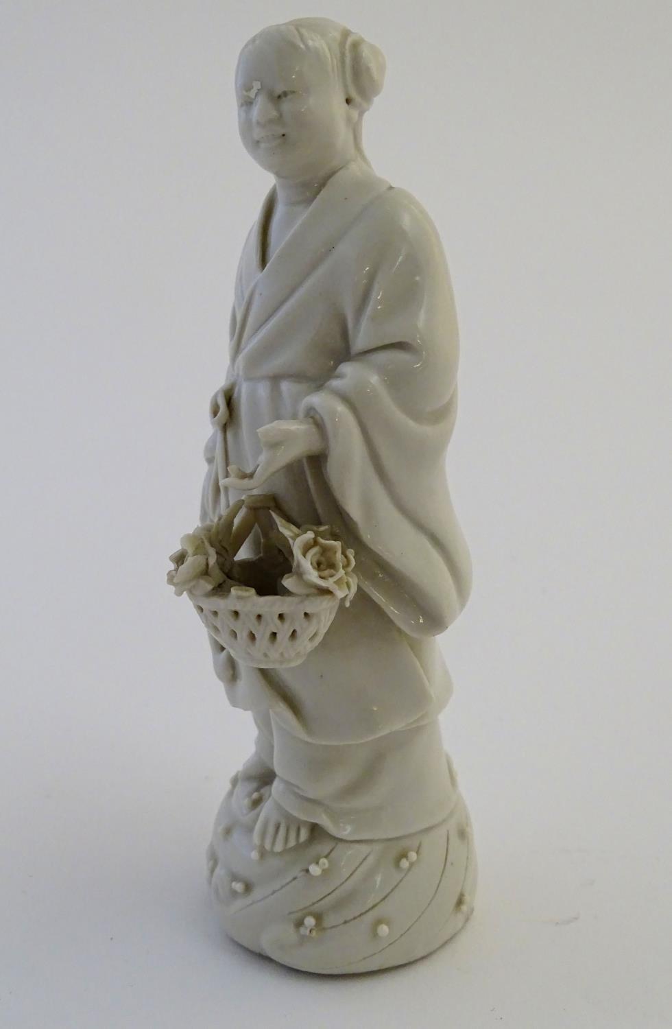 A Chinese blanc de chine depicting the Daoist Immortal figure, Lan Caihe, with a basket of - Image 4 of 9