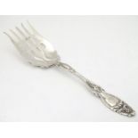 An American Sterling silver serving fork with fruiting vine decoration to handle. 9" long Please