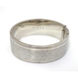 An Art Deco silver bracelet of bangle form with engine turned decoration. Hallmarked Birmingham 1932