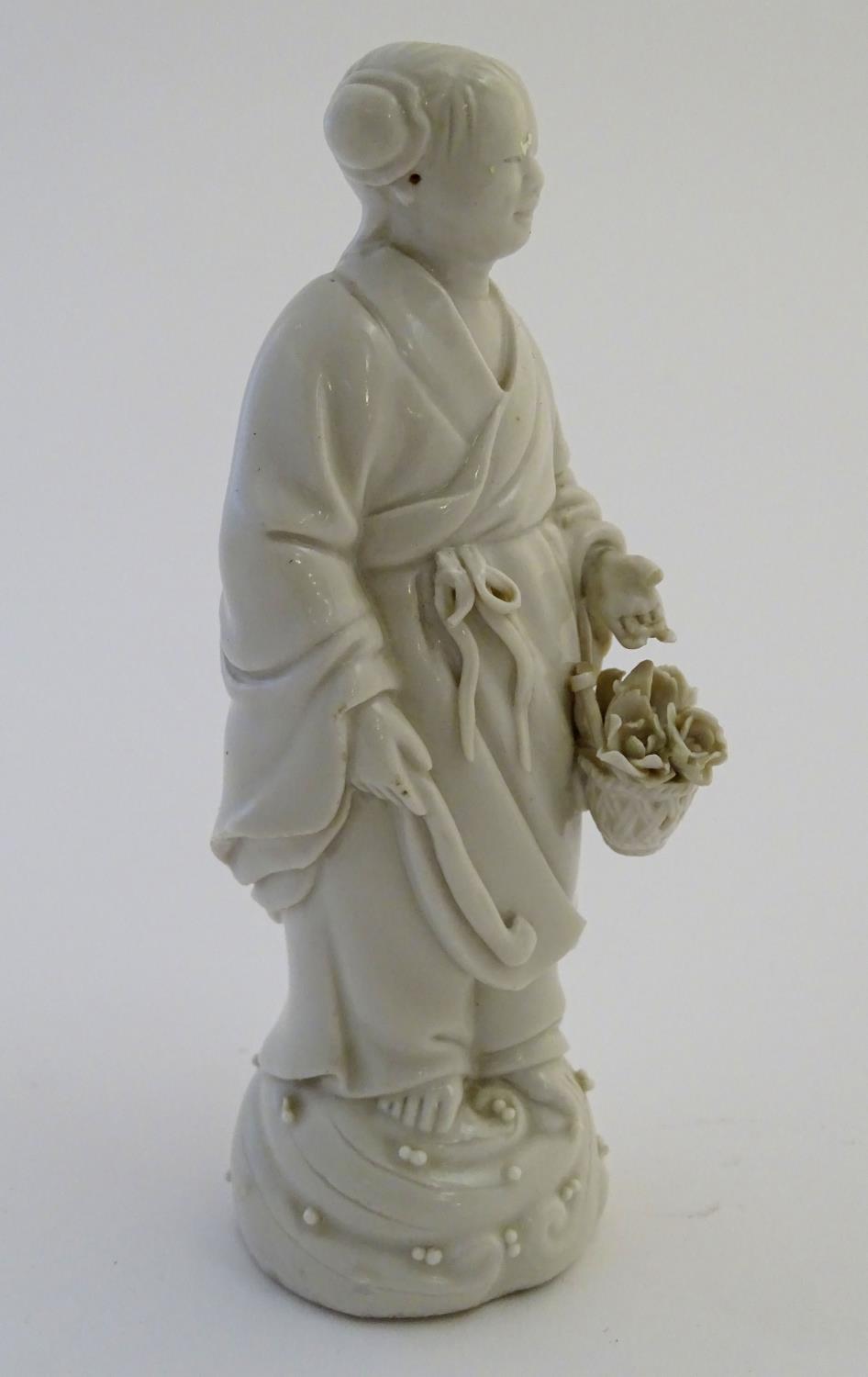 A Chinese blanc de chine depicting the Daoist Immortal figure, Lan Caihe, with a basket of - Image 3 of 9