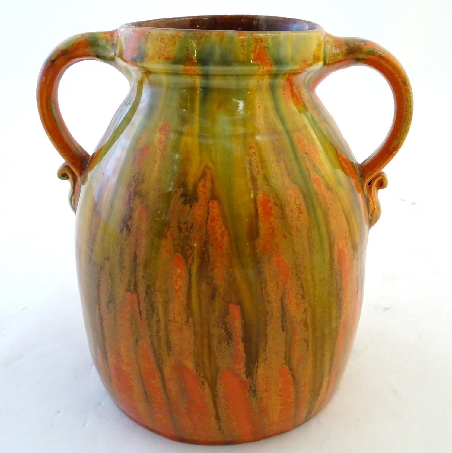 A Brannam of Barnstaple twin handled Barum ware vase with and orange and ochre drip glaze, the