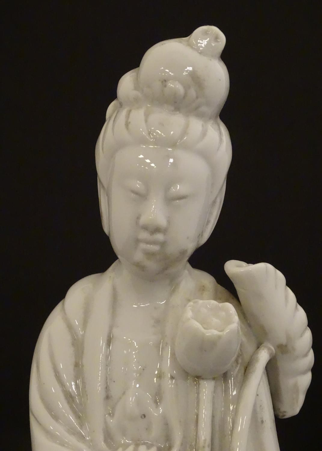 A Chinese blanc de chine figure of Guanyin holding flowers, raised on a base of lotus flowers and - Image 6 of 9