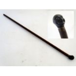 A walking stick / cane with a carved ebonised pommel formed as a male negro human head with an