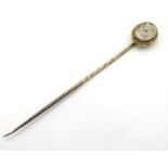 Mourning / memorial jewellery : A 19thC gilt metal stick pin surmounted by a locket containing